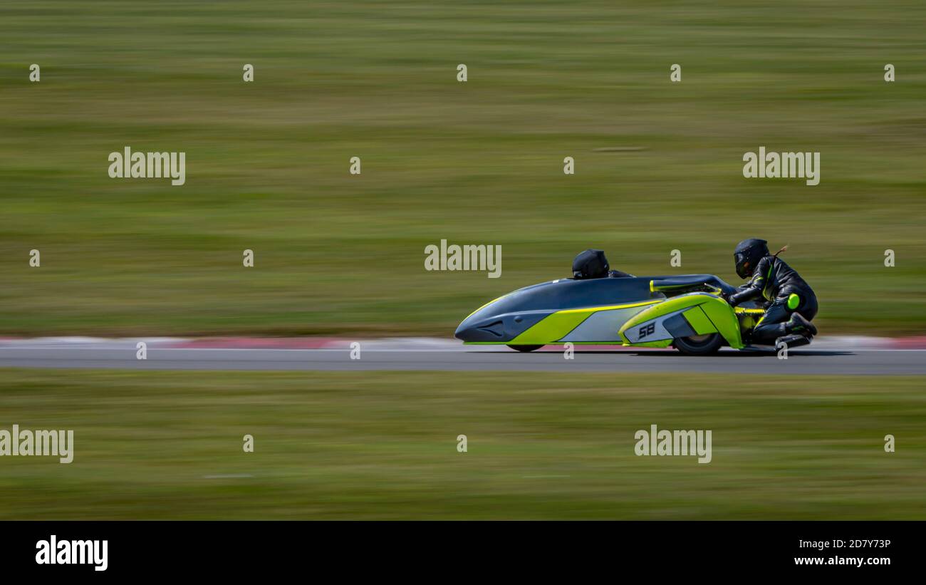Un cliché panoramique d'un side-car de course en virage sur une piste. Banque D'Images