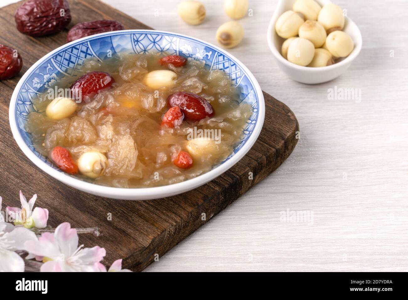 Gros plan de la soupe traditionnelle chinoise douce aux champignons blancs avec graines de lotus, dattes rouges (jujujube) et baies de carcajou (baie de goji, baie de gogyberry) sur le dos blanc Banque D'Images