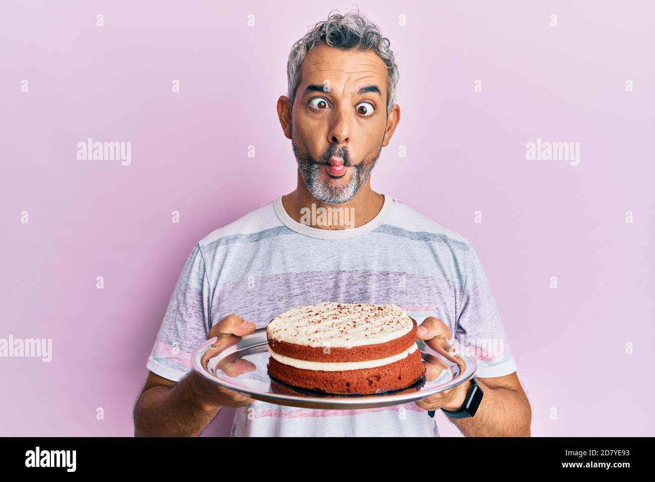 Moyen Age Gris Cheveux Homme Tenant Gateau De Carotte Faisant Le Visage De Poisson Avec La Bouche Et Les Yeux De Accroupi Fou Et Comique Photo Stock Alamy