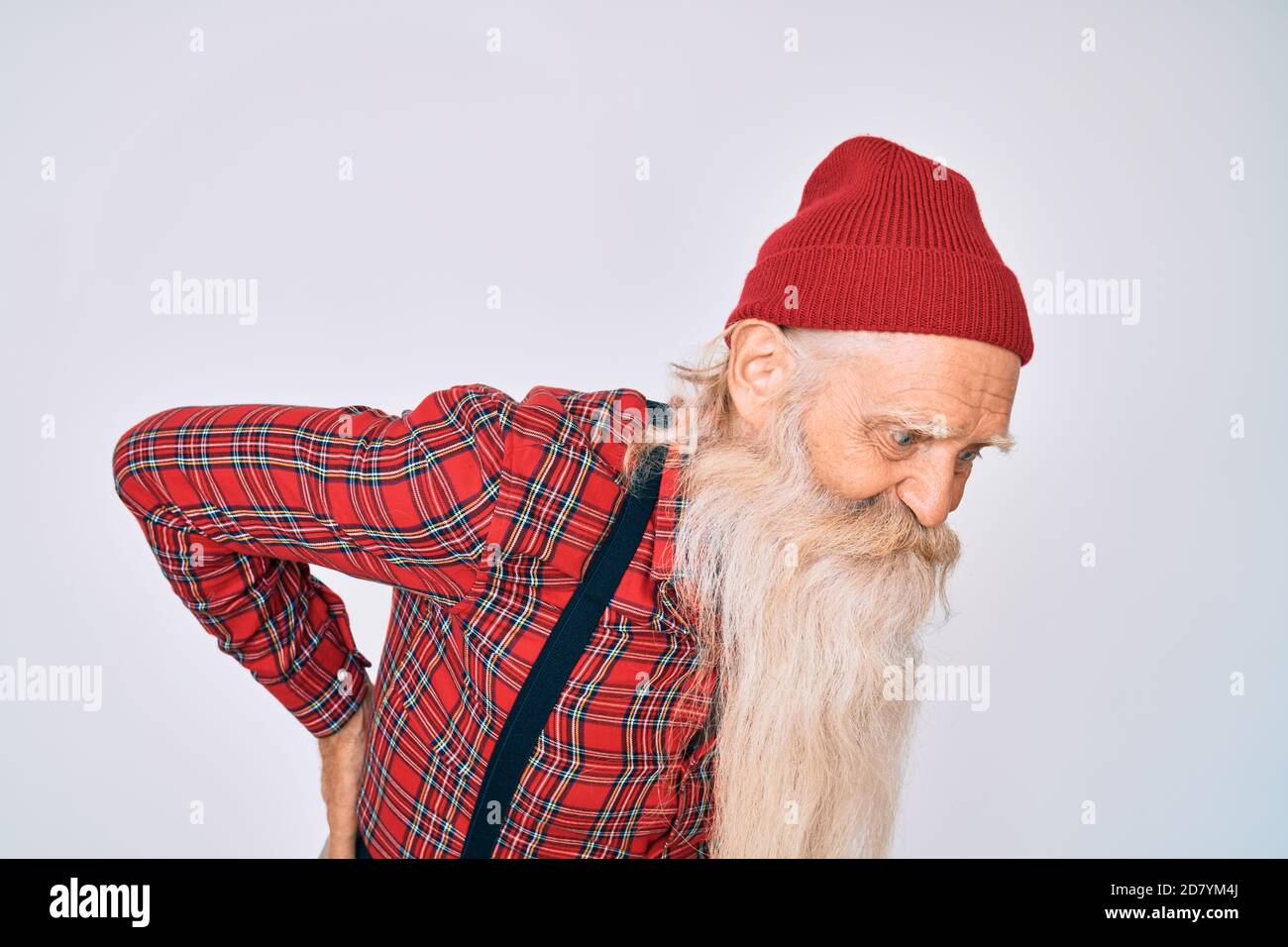 Vieux homme âgé avec cheveux gris et longue barbe porter l'allure de  hipster avec la casquette de laine souffrant de mal de dos, touchant le dos  avec la main, douleur musculaire Photo