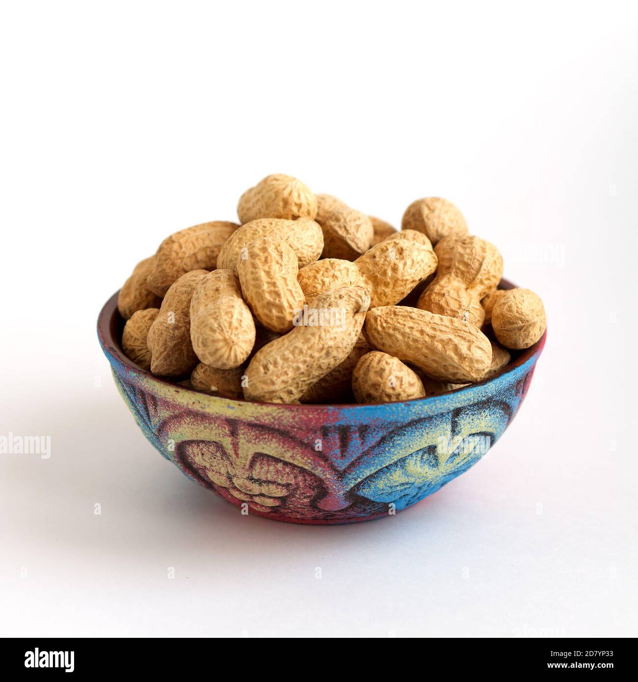 bol en argile avec arachides en coquille sur fond blanc Banque D'Images