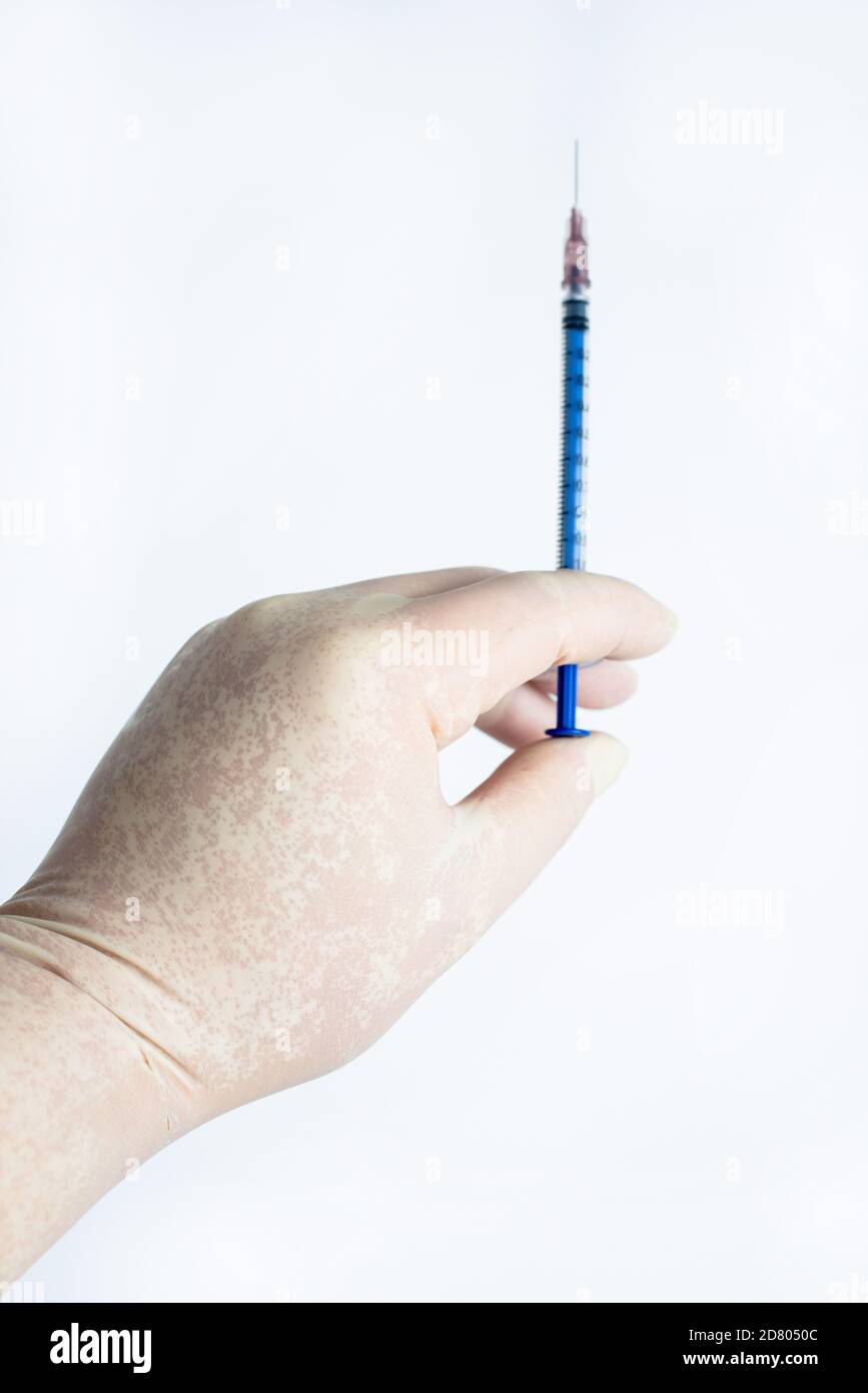Dans la main des gants en caoutchouc tenir une seringue Banque D'Images