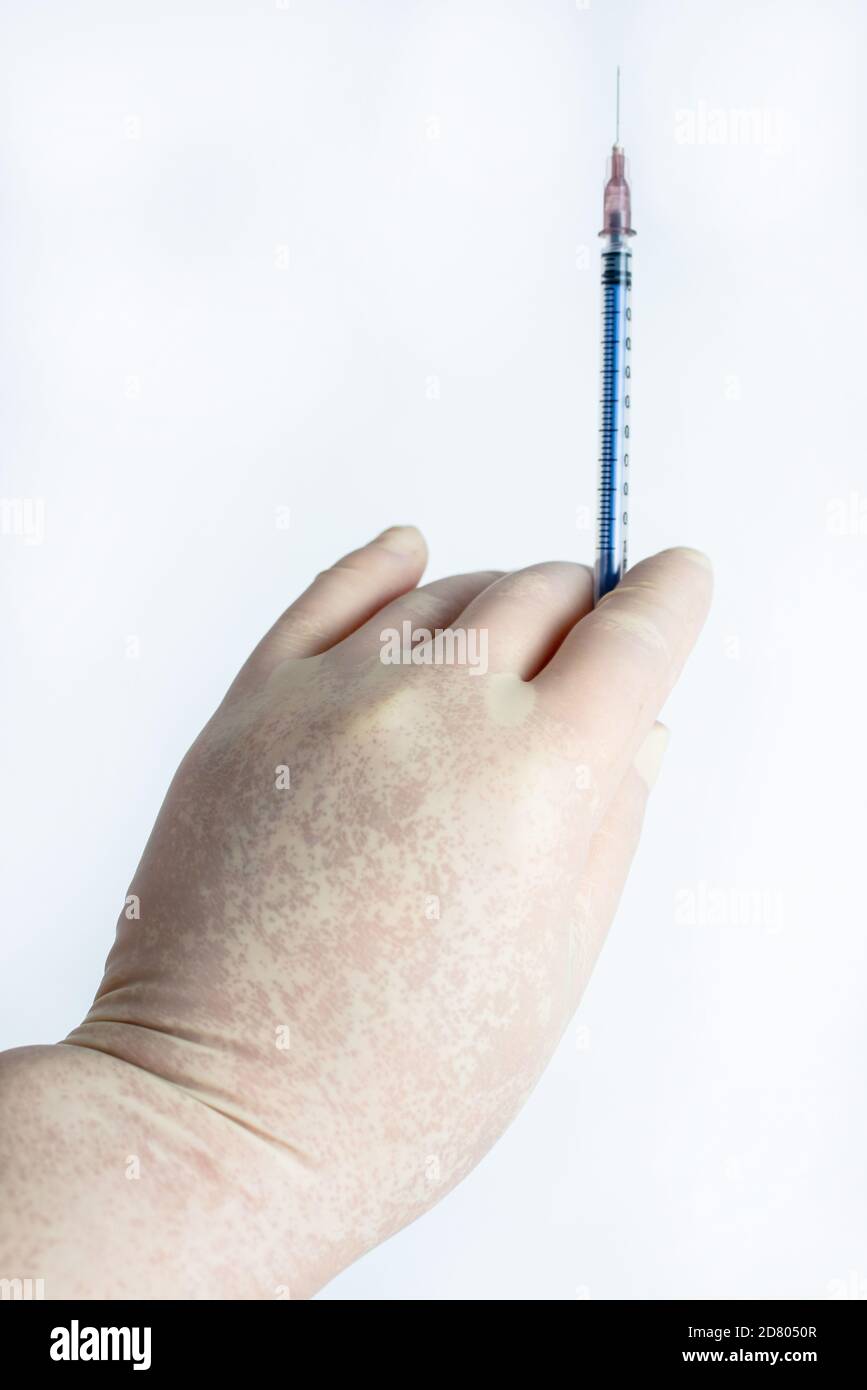 Dans la main des gants en caoutchouc tenir une seringue Banque D'Images