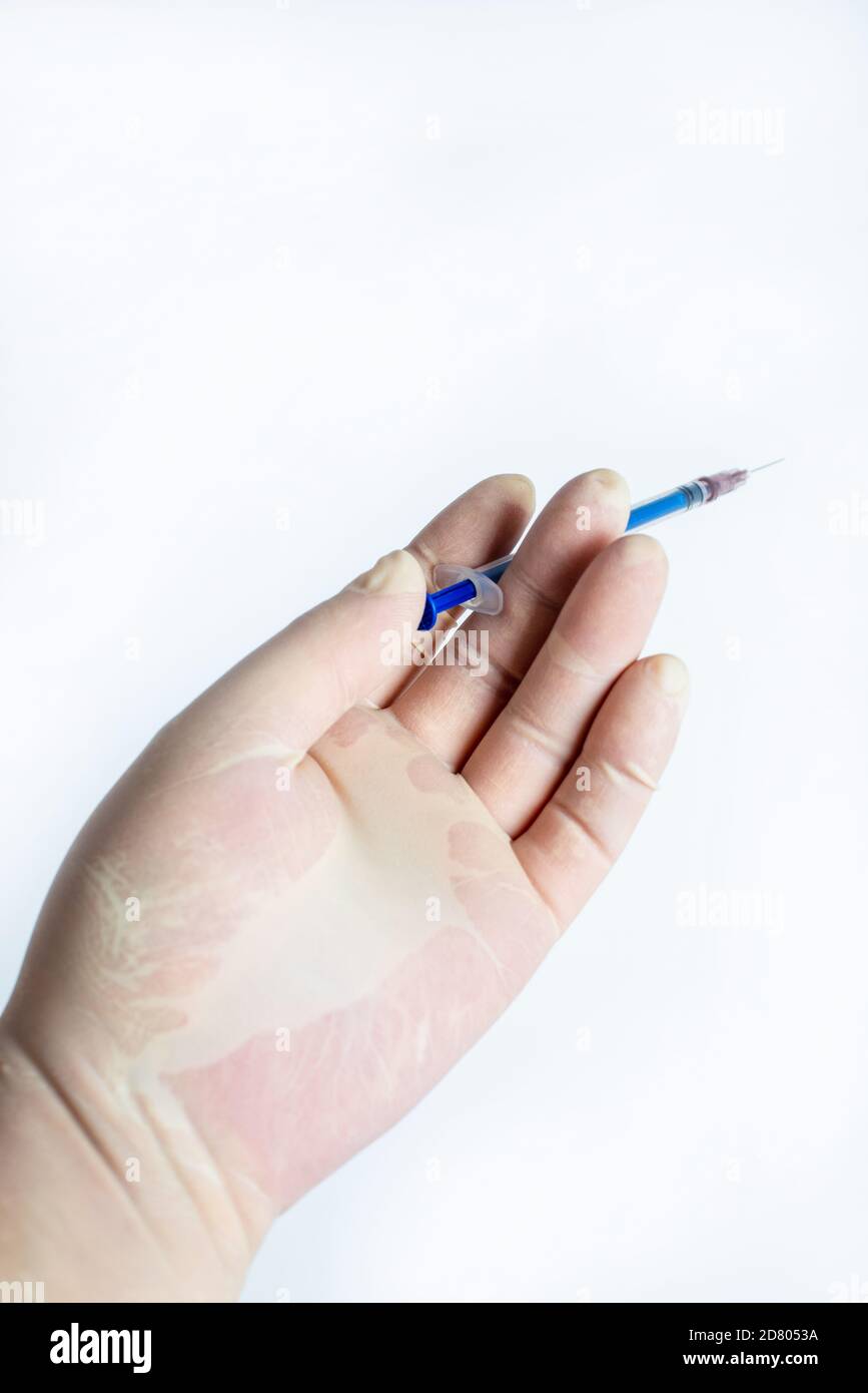 Dans la main des gants en caoutchouc tenir une seringue Banque D'Images