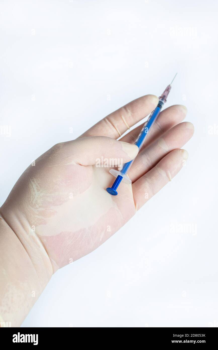 Dans la main des gants en caoutchouc tenir une seringue Banque D'Images