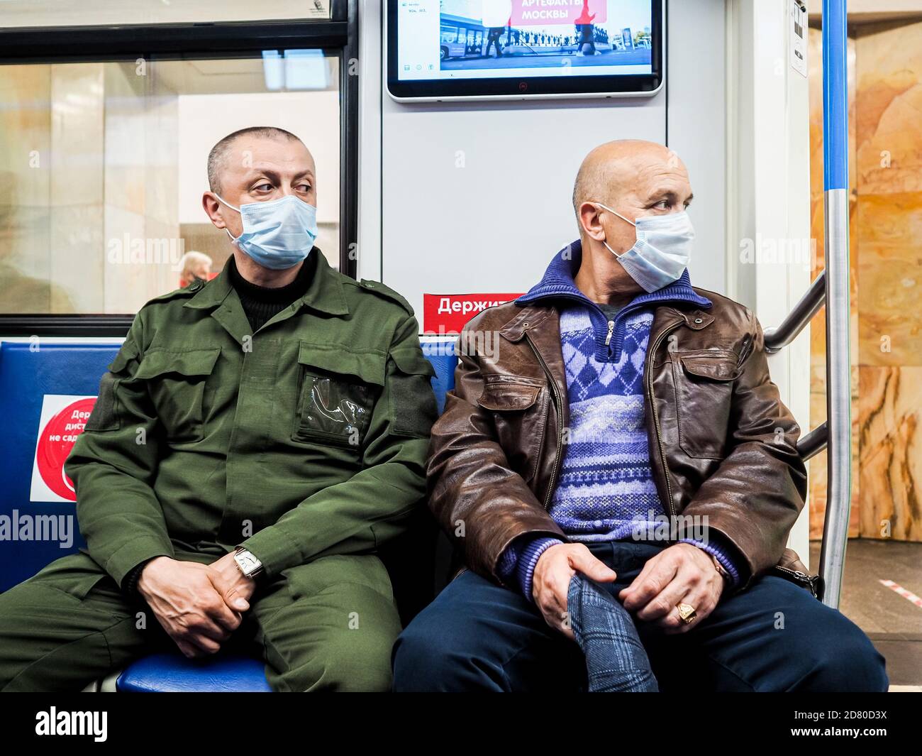 Moscou. Russie. 13 octobre 2020. Deux hommes sont assis sur un siège dans une voiture de métro. Sur le visage des passagers sont des masques de protection. Inscriptions dans Banque D'Images