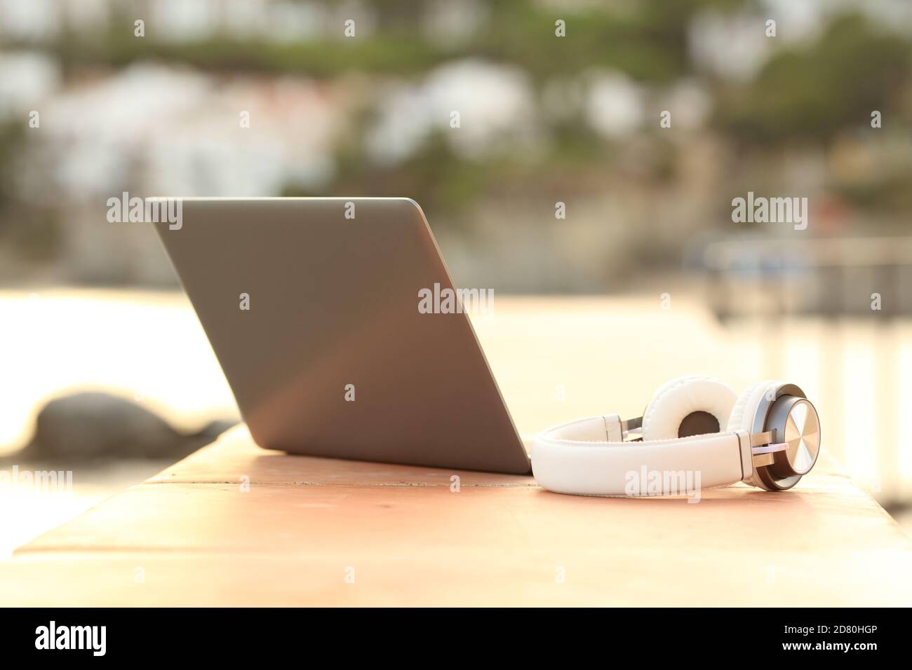 Gros plan d'un ordinateur portable et d'un casque sans fil sur un balcon sur la plage Banque D'Images