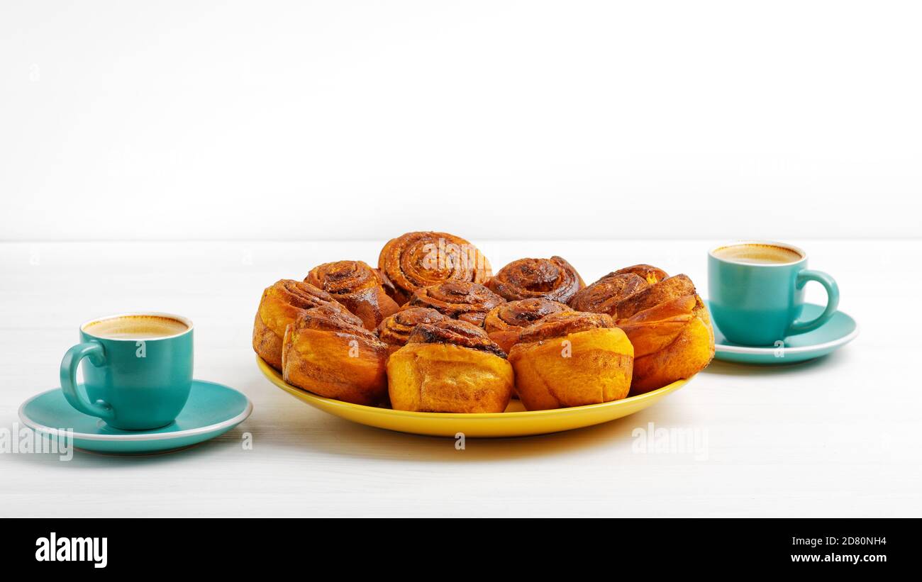 Petits pains à la cannelle faits maison à partir de pâte de levure et deux tasses d'espresso de café sur une table en bois blanc. CopySpace. Banque D'Images Petits pains à la cannelle faits maison à partir de pâte de levure et deux tasses d'espresso de café sur une table en bois blanc. CopySpace. Banque D'Images