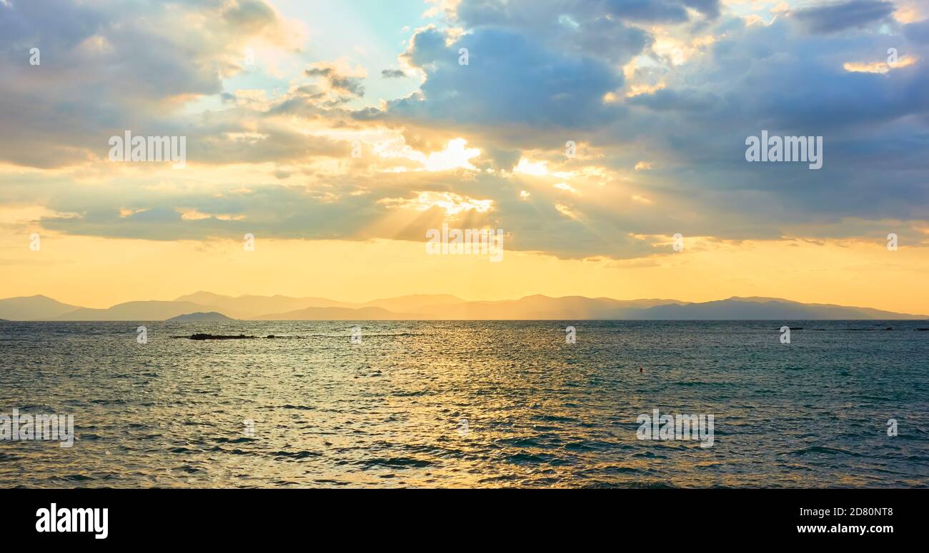 Vue panoramique sur la mer, les nuages et les rayons du soleil en soirée. Paysage Banque D'Images