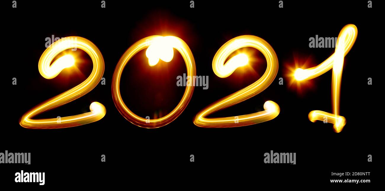 Bonne année 2021. Nubbmers jaunes créés par la lumière sur fond noir. Photographie de peinture légère, lettrage Banque D'Images