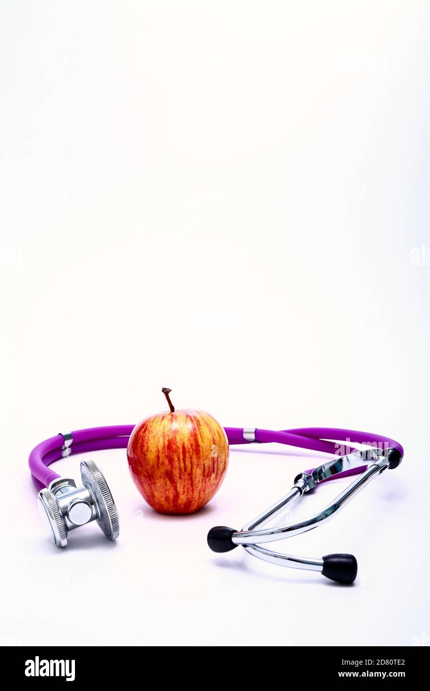 Image conceptuelle saine alimentation d'une pomme mangeant et de médecins stéthoscope avec espace de copie Banque D'Images