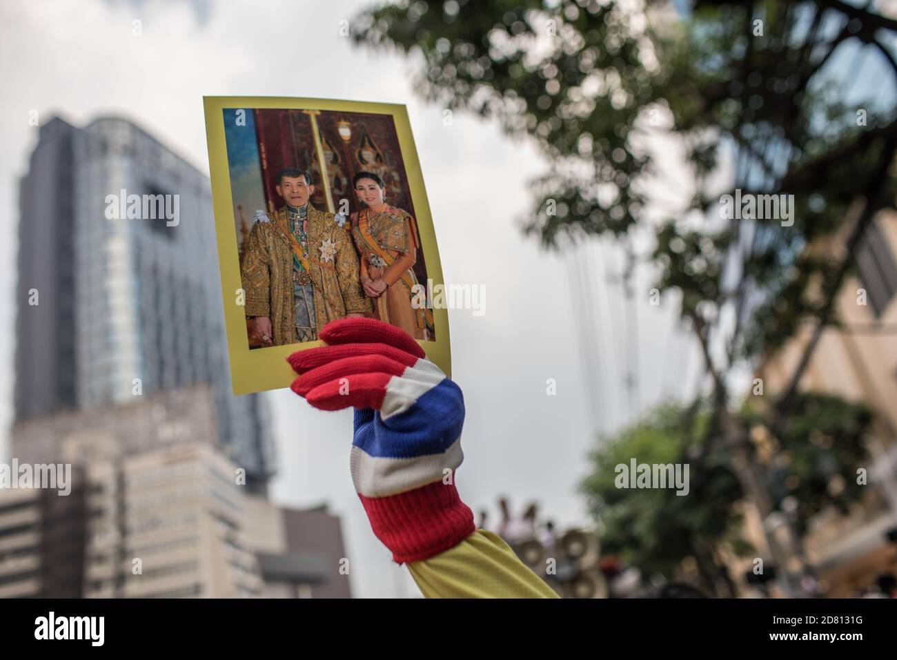 Un manifestant pro-monarchie tient un portrait du roi Maha Vajiralongkorn (Rama X) et de la reine Suthida Bajrasudhabimalakshana lors d'une manifestation devant l'ambassade d'Allemagne. Les manifestants de chemises jaunes se sont rassemblés devant l’ambassade d’Allemagne à Sathorn Road pour montrer leur soutien à la monarchie. Ils ont également soumis une lettre expliquant la situation politique en Thaïlande à l’ambassadeur Georg Schmidt, qui a été signé par Nitititititorn Lamlua et Pichit Chaimongkol du mouvement du « peuple de Thaïlande ». Banque D'Images