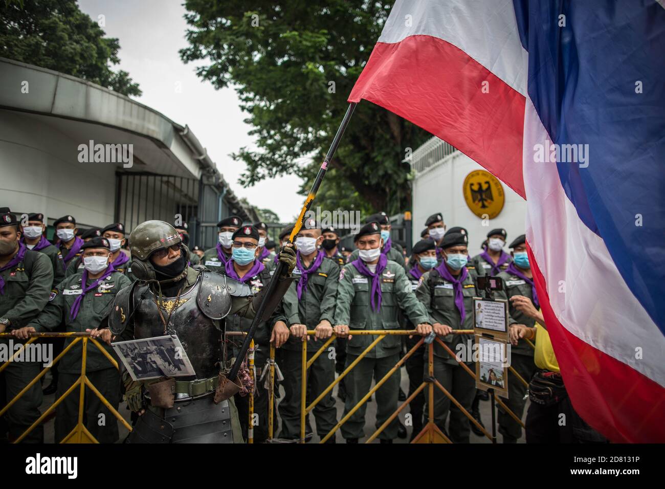 Un protestant pro-monarchie portant une tenue militaire a été vu porter le drapeau de la Thaïlande devant l'ambassade lors d'une manifestation à l'extérieur de l'ambassade d'Allemagne. Les manifestants de chemises jaunes se sont rassemblés devant l’ambassade d’Allemagne à Sathorn Road pour montrer leur soutien à la monarchie. Ils ont également soumis une lettre expliquant la situation politique en Thaïlande à l’ambassadeur Georg Schmidt, qui a été signé par Nitititititorn Lamlua et Pichit Chaimongkol du mouvement du « peuple de Thaïlande ». Banque D'Images