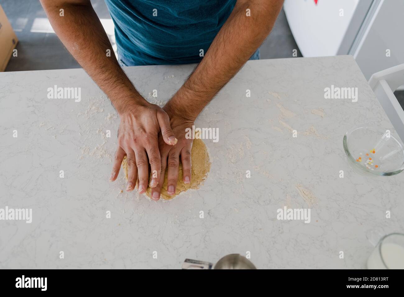 homme pétriant la pâte sur un comptoir de cuisine blanc Banque D'Images