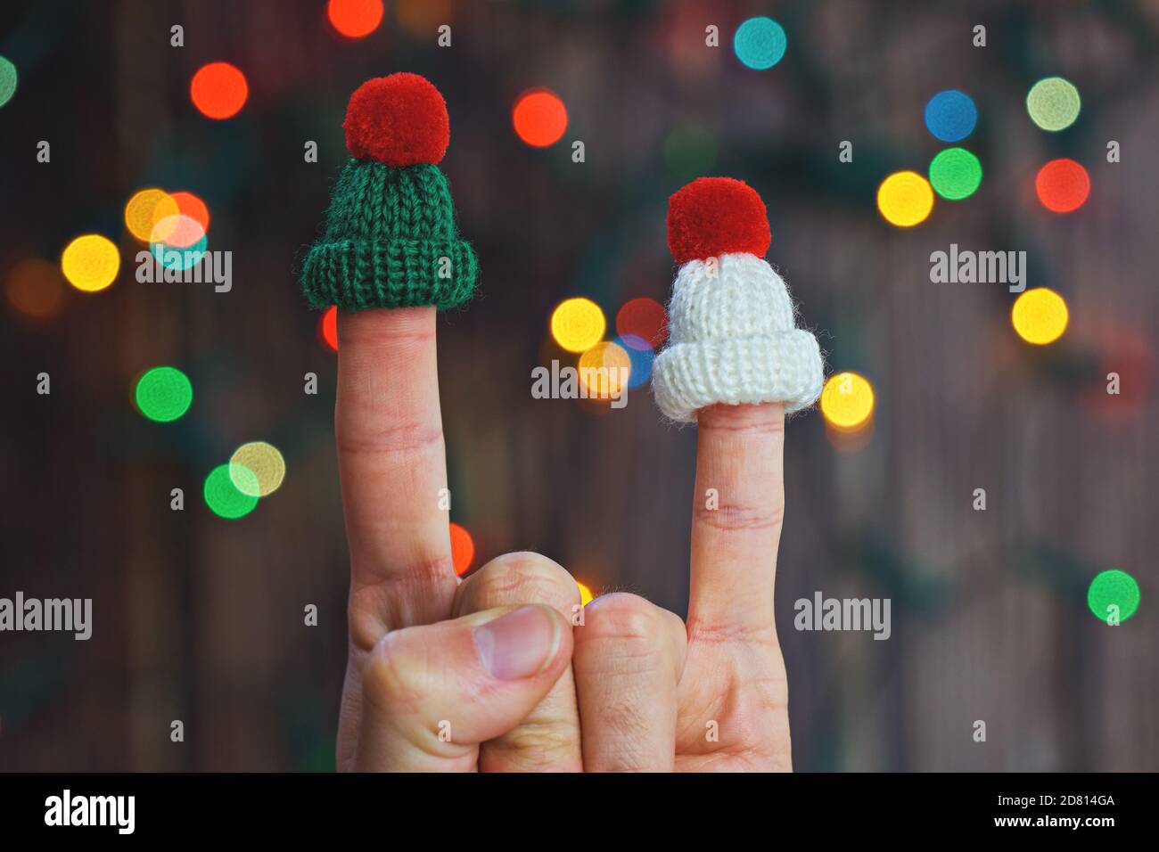 Bouc à bascule en chapeaux tricotés sur des lumières de Noël colorées arrière-plan bokeh Banque D'Images