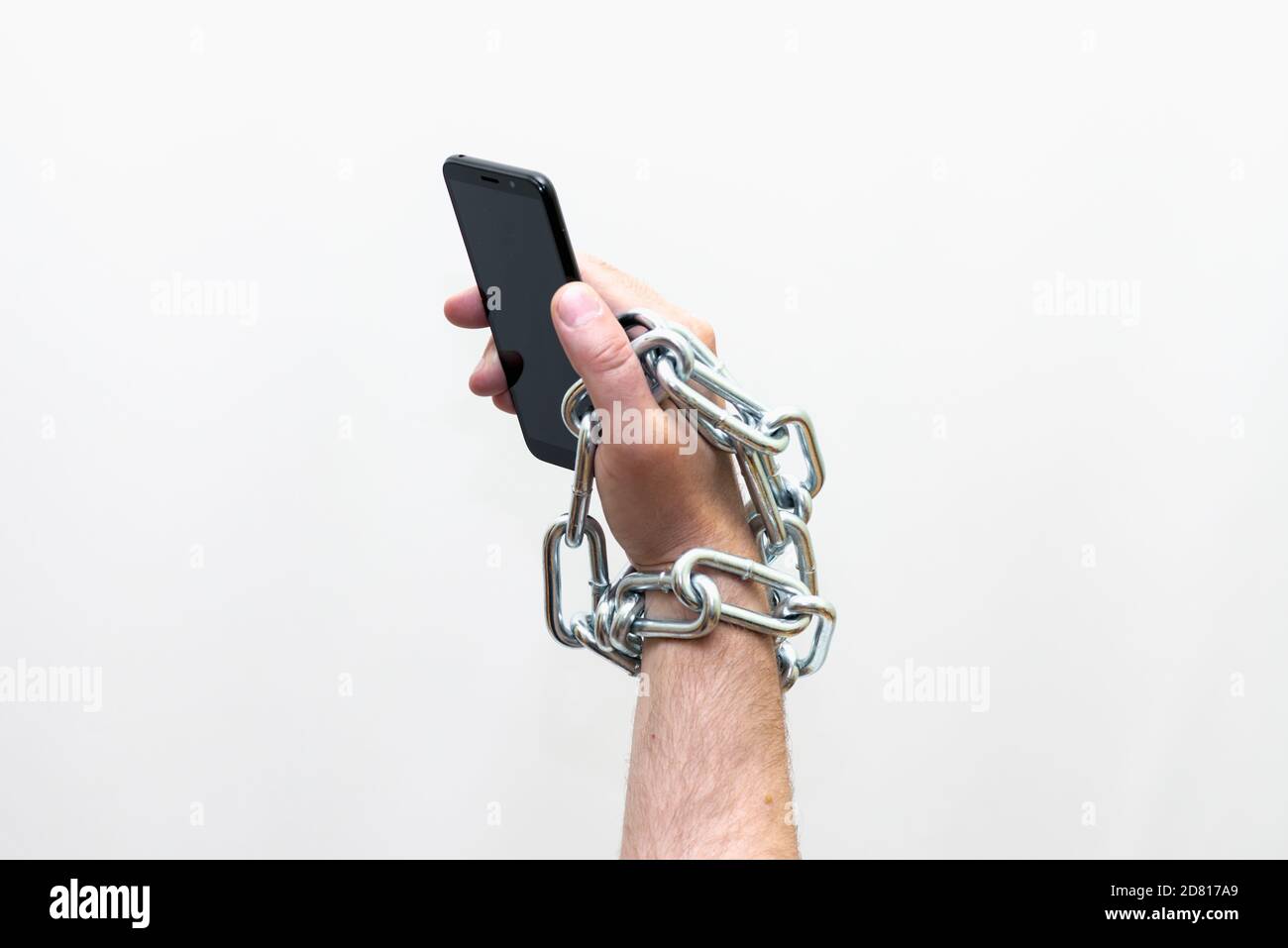 Gros plan Homme tenant un smartphone avec chaîne métallique sur fond blanc studio. Concept de sécurité Banque D'Images