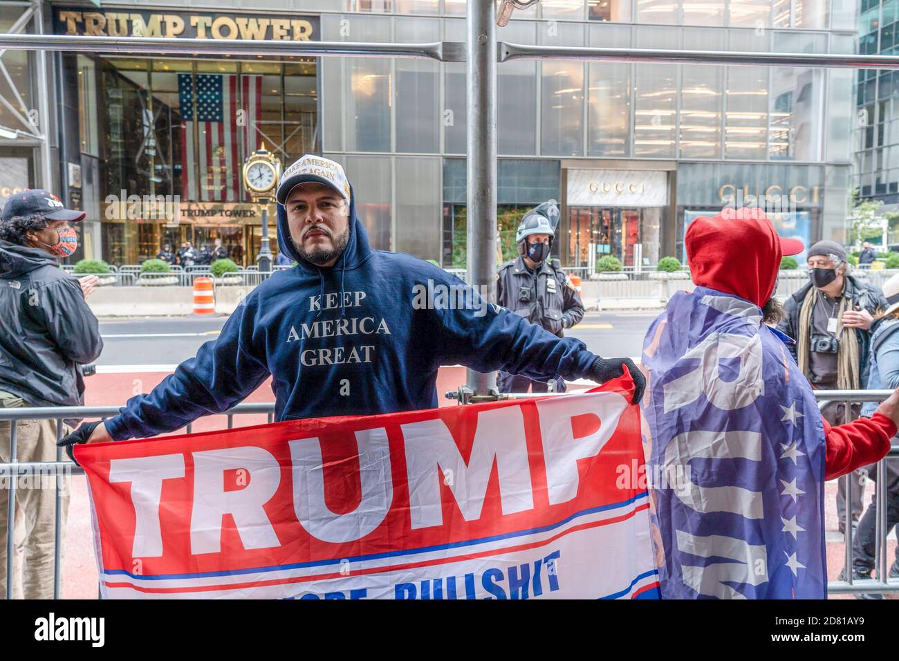 Un partisan du président Trump tient une bannière pendant la manifestation.les partisans du président pro-Trump défilent le long de la 5e avenue avec une caravane de voitures et un énorme drapeau bleu, blanc et noir de Trump. Ils marchent de la Trump Tower sur la 5e Avenue à la 42e rue et de là à Times Square où ils ont rencontré des contre-manifestants. Les manifestants anti-Trump ont lancé des insultes et des objets comme des bouteilles et des œufs remplis de peinture. Il y a eu beaucoup de bagarres entre ces deux groupes et la police a procédé à plus d'une douzaine d'arrestations. Banque D'Images