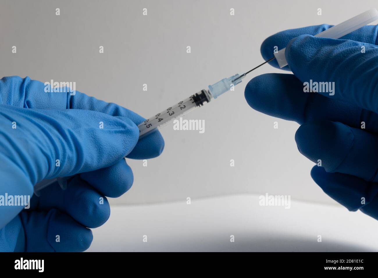 infirmière avec des gants en latex bleu pour découvrir la seringue à aiguille Banque D'Images