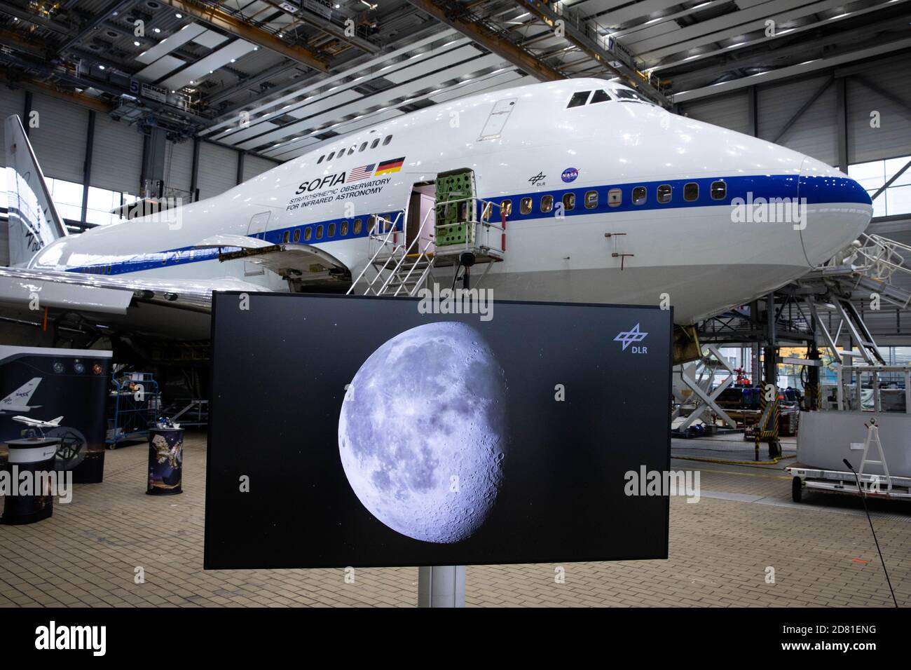 Hambourg, Allemagne. 26 octobre 2020. Lors d'une conférence de presse, un moniteur montrant une photo de la lune se tient devant le Boeing 747 converti avec l'Observatoire stratosphérique d'astronomie infrarouge (Sofia), qui est dans un hangar de Lufthansa Technik pour maintenance. LES chercheurs AMÉRICAINS ont trouvé de nouvelles preuves de l'eau sur la lune. (Aux 'chercheurs trouvent de nouvelles preuves de l'eau sur la lune') Credit: Christian Charisius/dpa/Alamy Live News Banque D'Images
