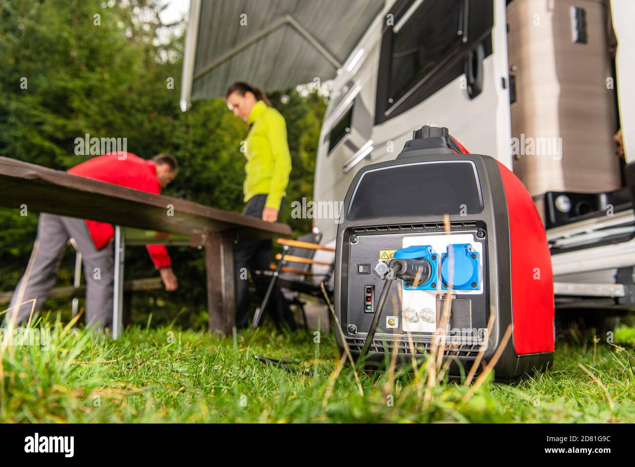 Génératrice à essence moderne fonctionnant à côté d'une fourgonnette de tourisme. Alimentation du terrain de camping RV avec sa propre source d'énergie. Banque D'Images