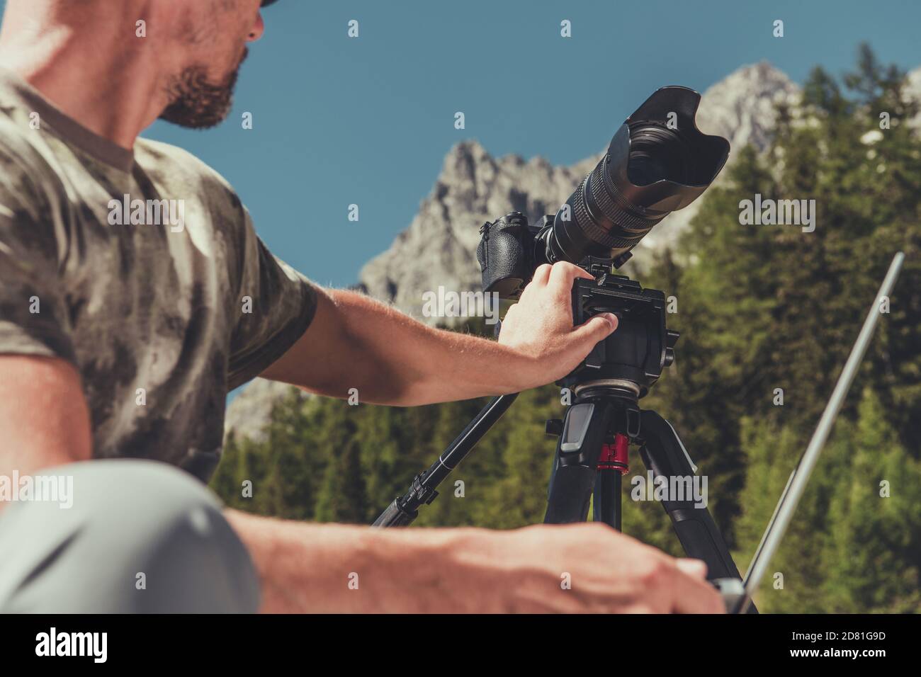 Le photographe de race blanche prépare son appareil photo pour la photographie de paysage dans la région des montagnes panoramiques. Banque D'Images