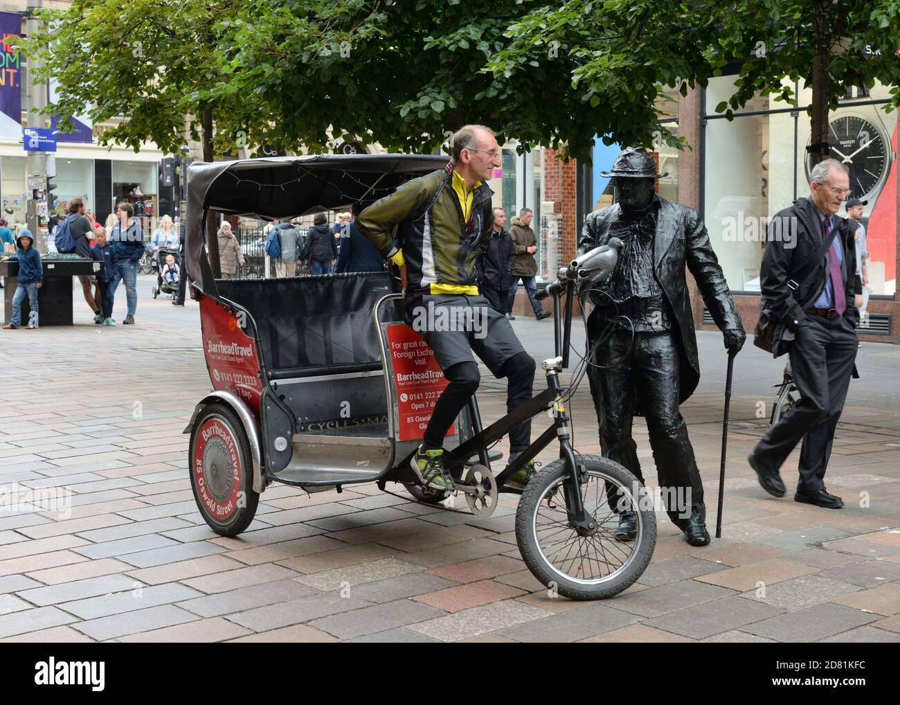 Un chauffeur de taxi tricycle s'arrête pour discuter avec un busseur de statue humaine sur Buchanan Street, Glasgow, Écosse, Royaume-Uni Banque D'Images