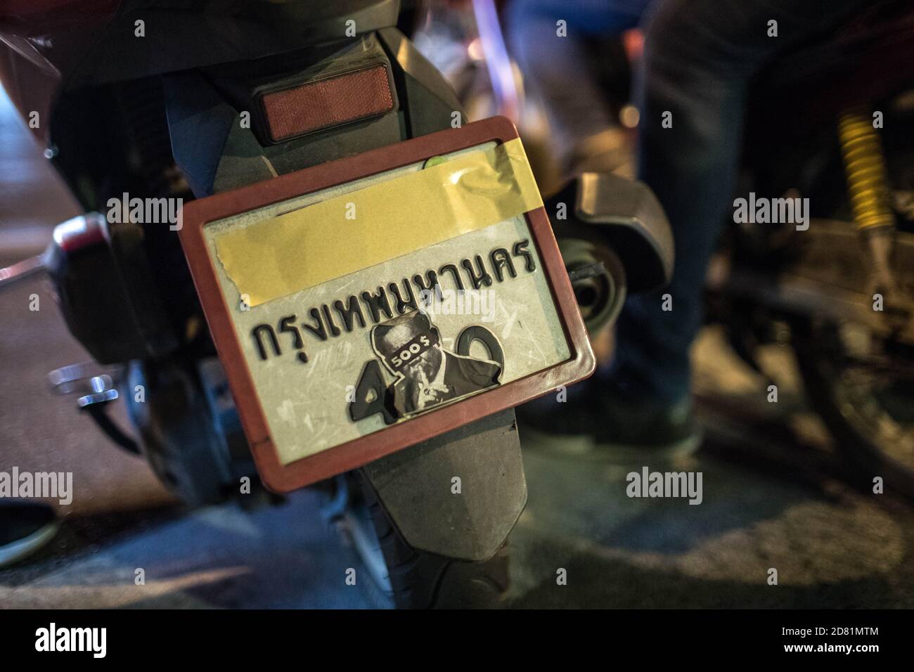 Bangkok, Thaïlande. 26 octobre 2020. Un motocycliste a caché sa plaque de moto avec du ruban adhésif et un autocollant du Premier ministre Prayut Chan-o-cha lors d'une manifestation antigouvernementale dans la capitale thaïlandaise. Des milliers de manifestants pro-démocratie ont défilé de Samyan intersection à l'ambassade d'Allemagne pour remettre une lettre demandant une enquête sur la résidence du roi thaïlandais (Rama X) Maha Vajiralongkorn en Allemagne, ainsi que pour demander la démission du Premier ministre thaïlandais et la réforme de la monarchie. Crédit : SOPA Images Limited/Alamy Live News Banque D'Images