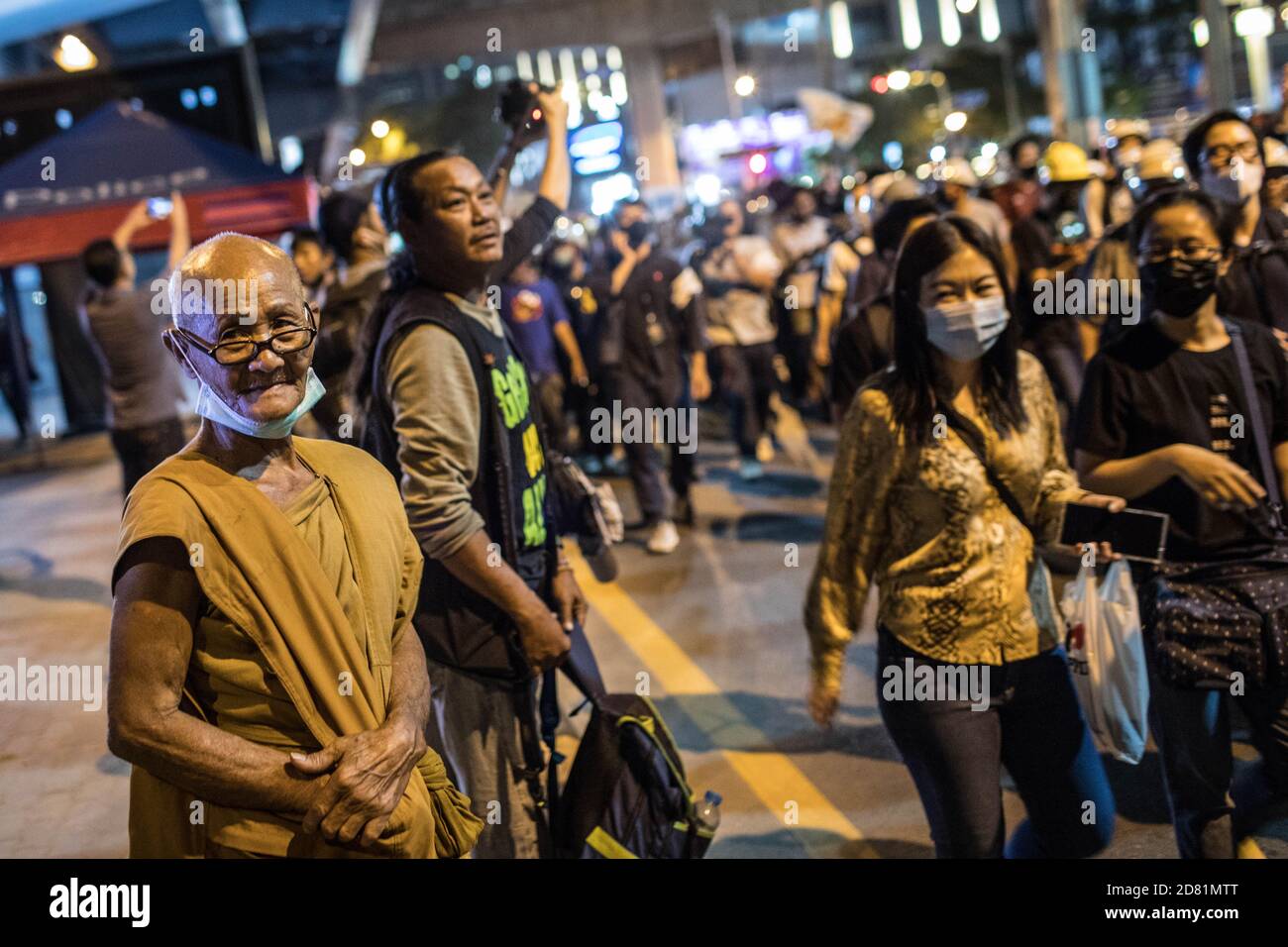 Bangkok, Thaïlande. 26 octobre 2020. Un moine du bouddhisme regarde les manifestants lors d'une manifestation anti-gouvernementale dans la capitale thaïlandaise. Des milliers de manifestants pro-démocratie ont défilé de Samyan intersection à l'ambassade d'Allemagne pour remettre une lettre demandant une enquête sur la résidence du roi thaïlandais (Rama X) Maha Vajiralongkorn en Allemagne, ainsi que pour demander la démission du Premier ministre thaïlandais et la réforme de la monarchie. Crédit : SOPA Images Limited/Alamy Live News Banque D'Images