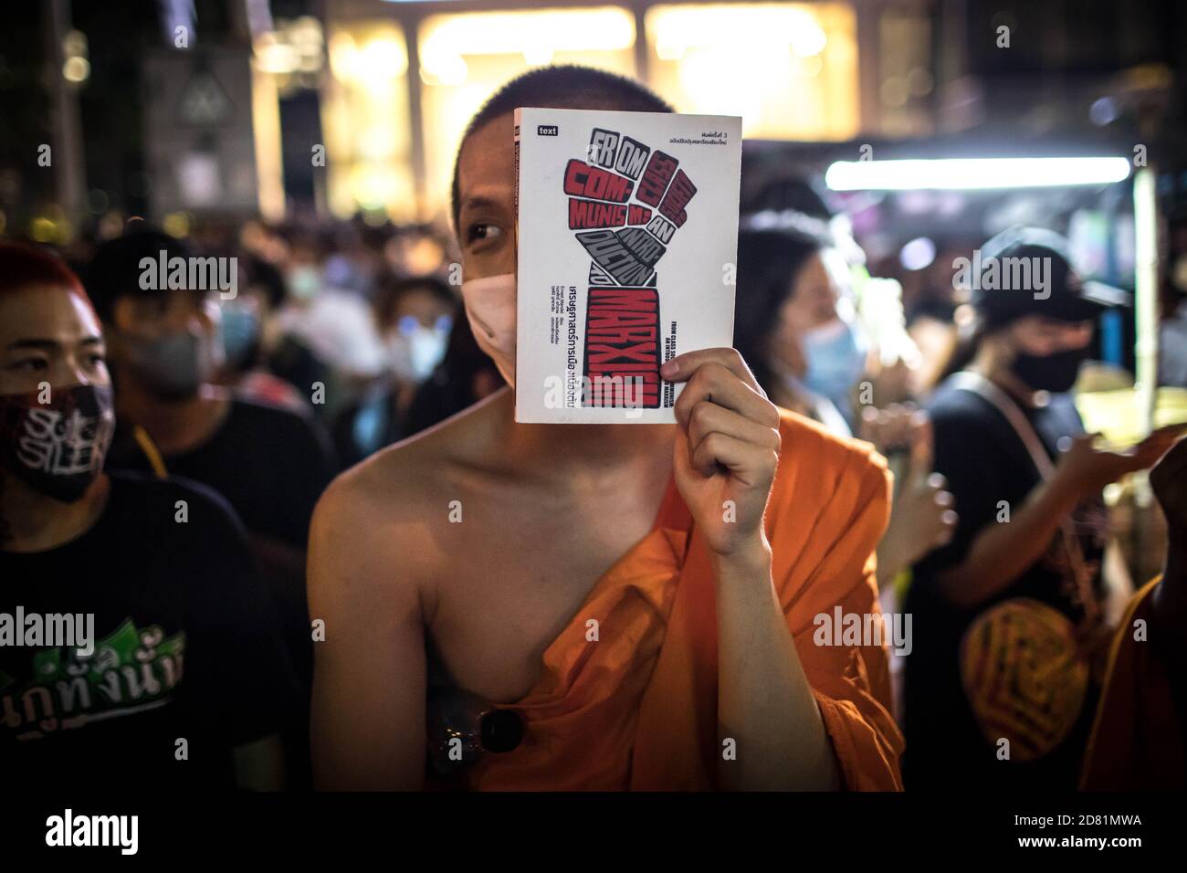 Bangkok, Thaïlande. 26 octobre 2020. Un moine bouddhiste tient un livre tout en couvrant partiellement son visage lors d'une manifestation anti-gouvernementale dans la capitale thaïlandaise. Des milliers de manifestants pro-démocratie ont défilé de Samyan intersection à l'ambassade d'Allemagne pour remettre une lettre demandant une enquête sur la résidence du roi thaïlandais (Rama X) Maha Vajiralongkorn en Allemagne, ainsi que pour demander la démission du Premier ministre thaïlandais et la réforme de la monarchie. Crédit : SOPA Images Limited/Alamy Live News Banque D'Images