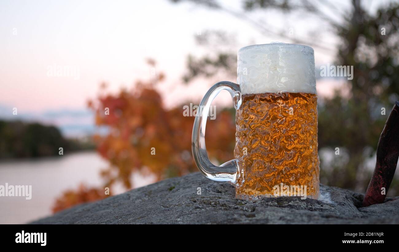 Une bière blonde froide est posée sur les rochers de l'archipel suburbain à Stockholm, en Suède, lors d'une soirée d'automne froide et fraîche. Banque D'Images