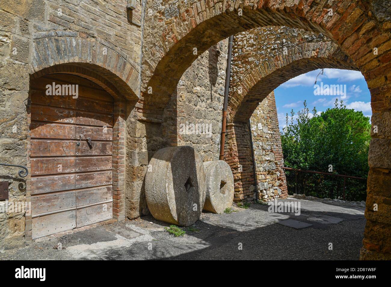 Aperçu d'une allée voûtée dans le village médiéval avec de vieilles pierres contre le mur d'une ancienne maison, San Gimignano, Sienne, Toscane, Italie Banque D'Images