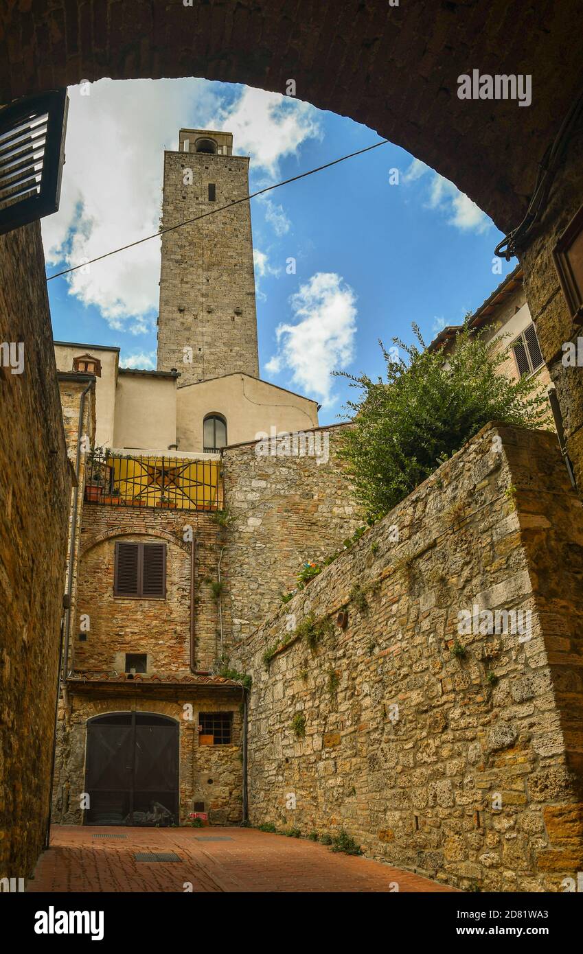 Aperçu de la vieille ville de San Gimignano, site classé au patrimoine mondial de l'UNESCO, depuis une allée voûtée avec la Torre Rognosa médiévale, Sienne, Toscane, Italie Banque D'Images
