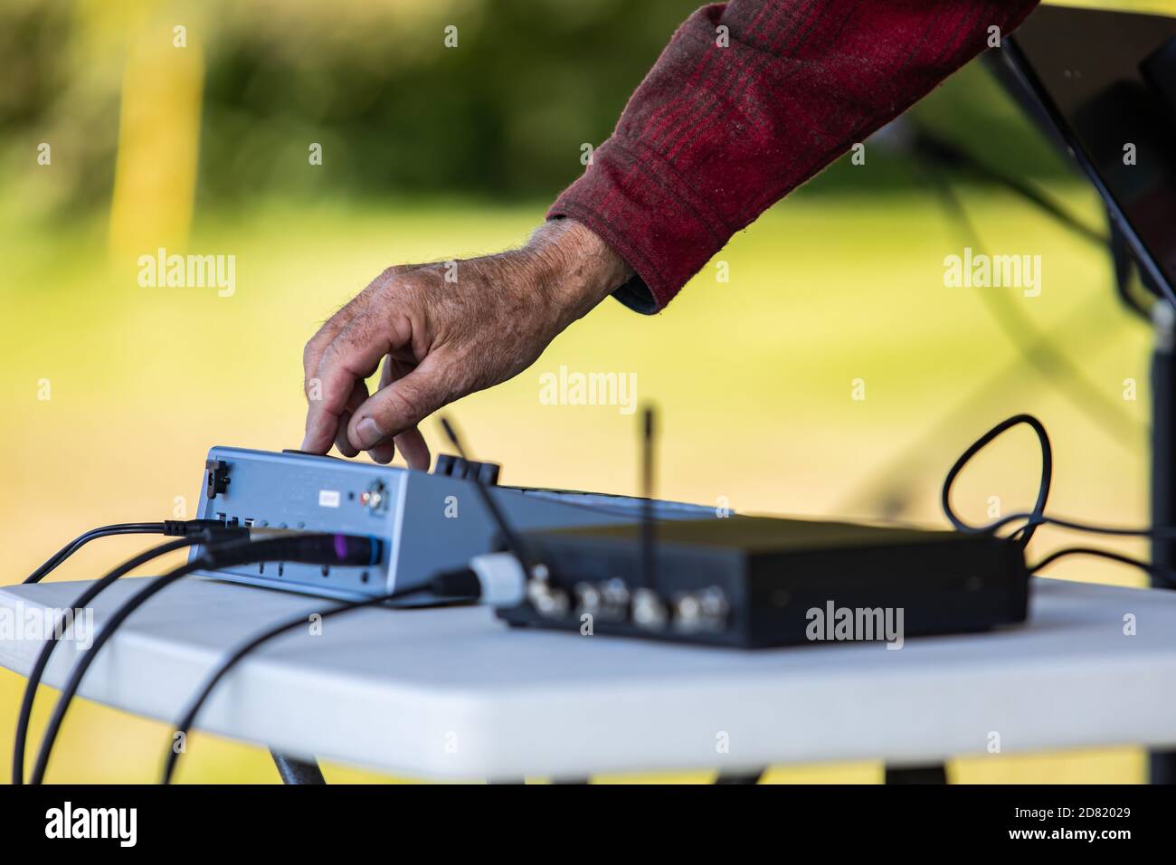 Concentration sélective des mains de DJ mâle travaillant sur l'électricité égalisateur de son en ajustant le système pendant la fête culturelle sur le lieu Banque D'Images