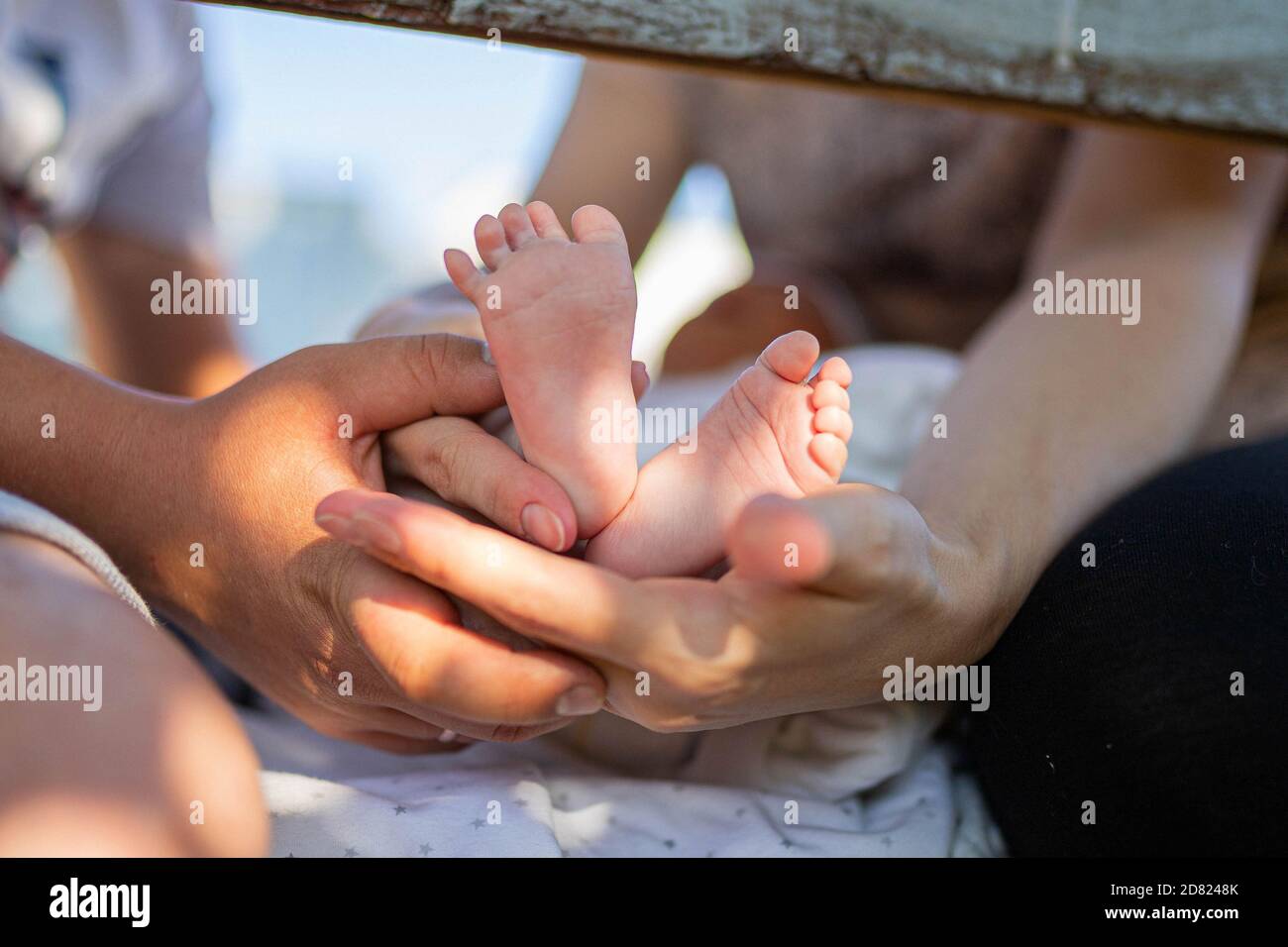 Parents tenant les pieds de bébé nouveau-né. Extérieur. Gros plan Banque D'Images