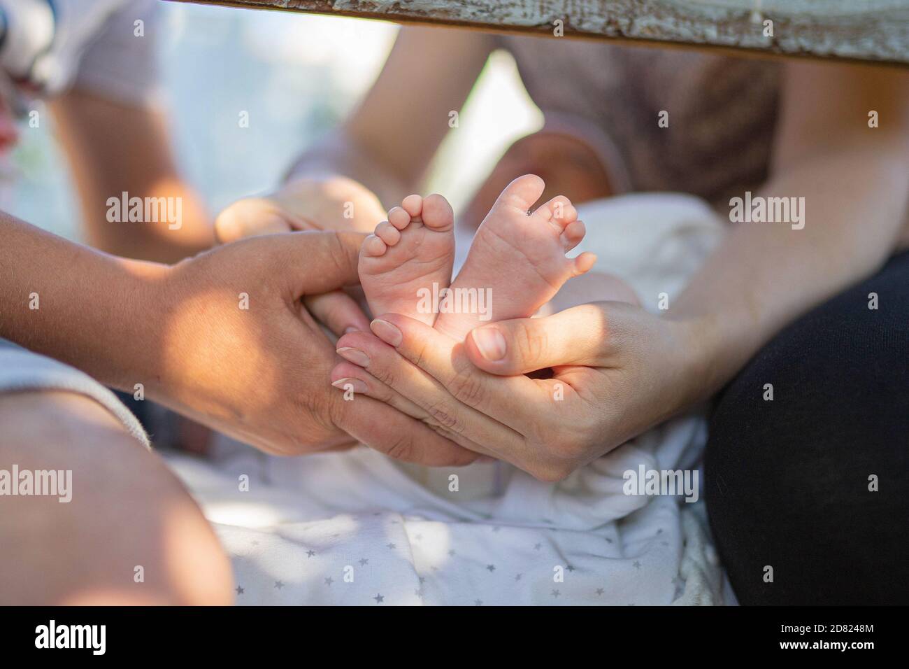 Parents tenant des pieds de bébé. À l'extérieur. Gros plan Banque D'Images