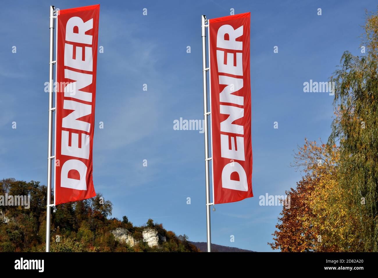 Deux drapeaux de magasin appelé Denner, magasin de rabais en Suisse, photographiés un jour d'automne clair. Banque D'Images