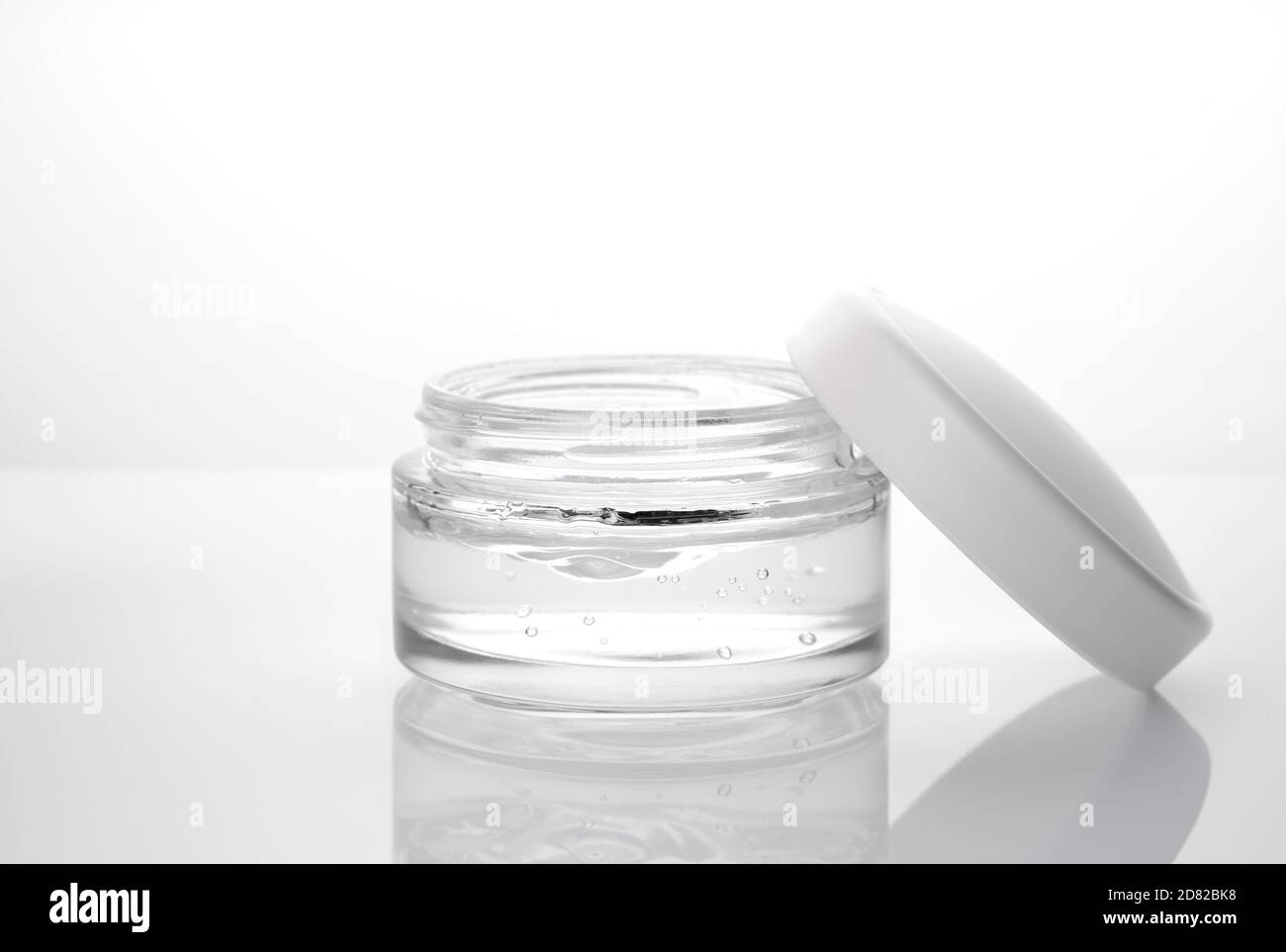 Ouvrez le bol transparent avec de la crème sur un fond brillant. Banque D'Images