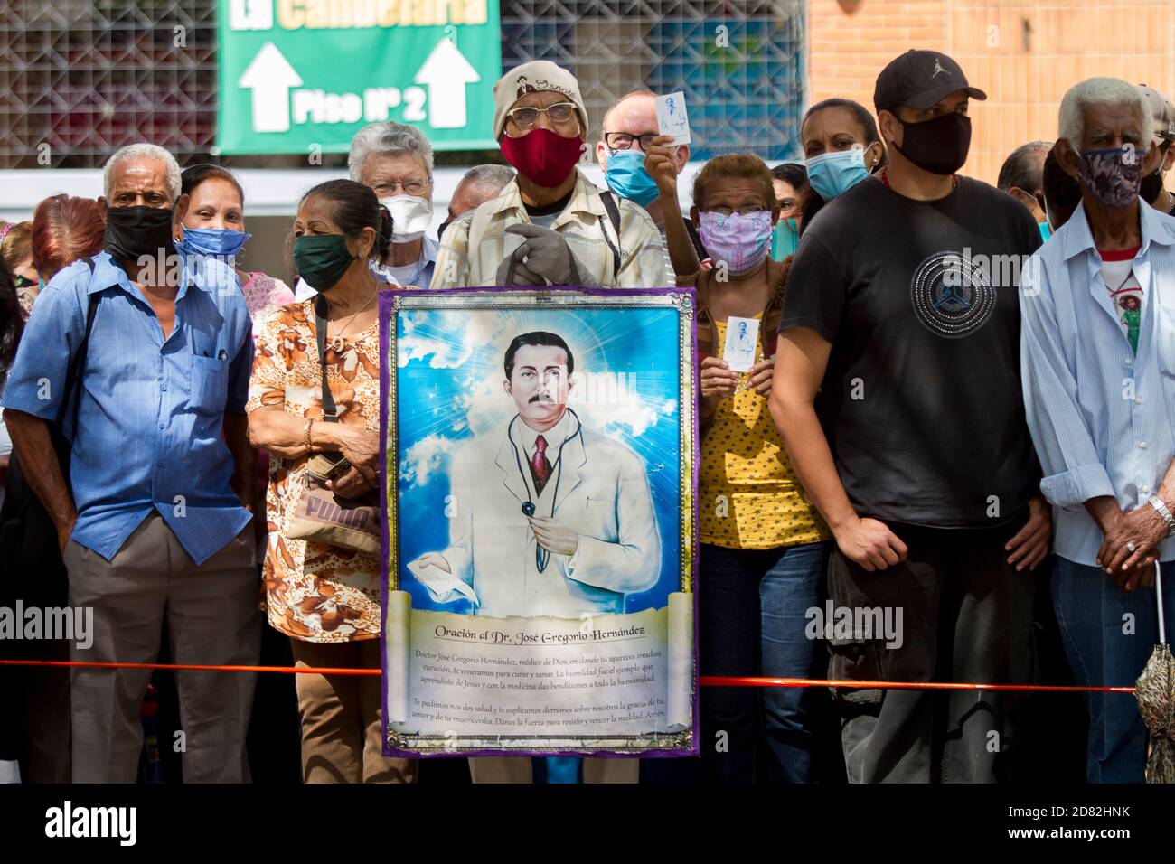 Caracas, Venezuela. 26 octobre 2020. Fidèles avec des masques de visage se trouvent devant l'église 'Nuestra Señora de la Candelaria', où les restes du docteur Jose Gregorio Hernandez, qui est mort en 1919, sont excavés. L'exhumation, qui a eu lieu en présence de témoins, a été réalisée dans le cadre du processus de béatification du Venezuela. Hernandez est vénéré par beaucoup de croyants dans le pays sud-américain. Credit: Pedro Rances Mattey/dpa/Alay Live News Banque D'Images