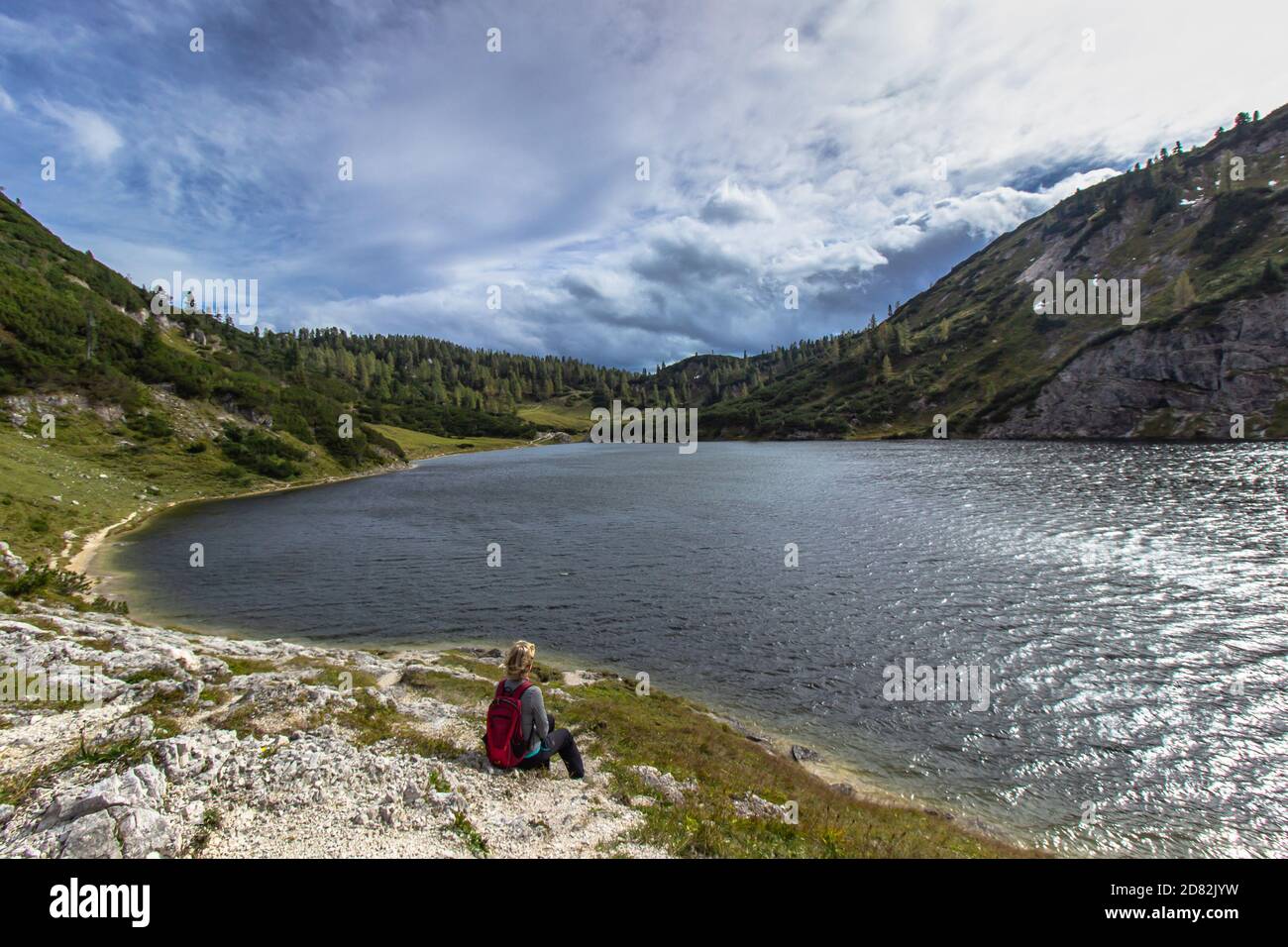 Active fille sportive ayant un repos sur le pic des Alpes, Autriche. Backpacker offrant une vue sur les montagnes et le lac. Concept de voyage de la liberté de Wanderlust Banque D'Images