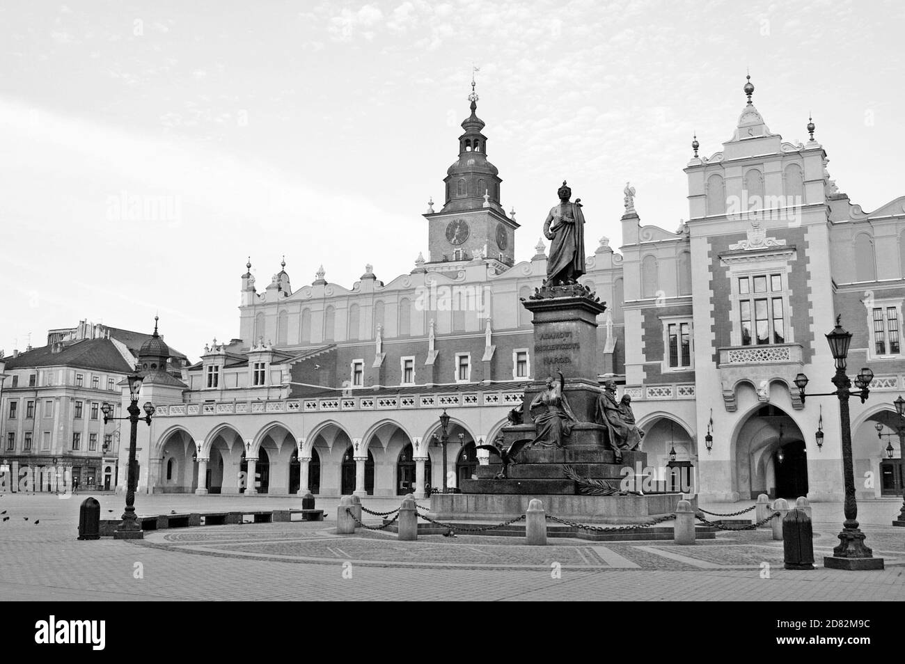 Photo en début de matinée en noir et blanc de la place du marché principal déserte avec le marché en tissu et le monument Mickiewicz dans la vieille ville de Cracovie, en Pologne. Banque D'Images