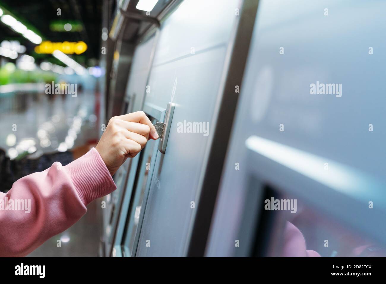 Femme insère à la main une pièce pour acheter un billet de métro dans la machine. Concept de transport Banque D'Images