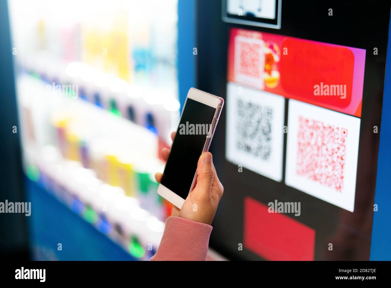 Paiement par code QR, achats en ligne, concept de technologie sans espèces. Les femmes tiennent le smartphone pour le paiement à la machine du fournisseur Banque D'Images