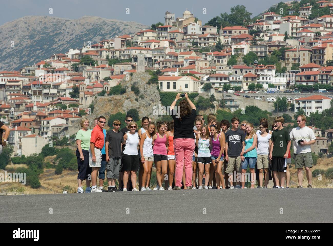 Arachova, Grèce - 27 juillet 2009 : un groupe scolaire touristique pose pour une photo ; en arrière-plan, le village d'Arachova en Grèce (le village est flou Banque D'Images
