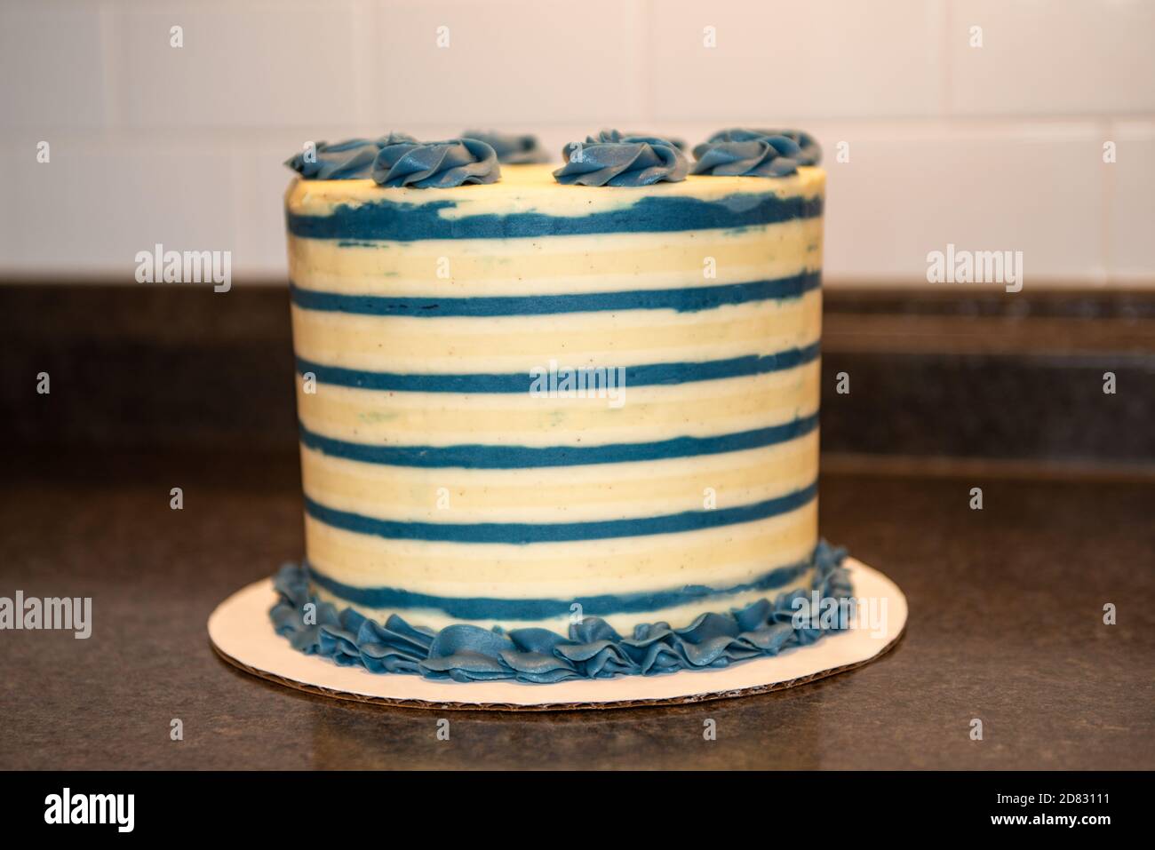 Un gâteau d'anniversaire rond blanc et bleu dépoli à plusieurs couches. Le  grand gâteau a des rosettes bleues sur le dessus Photo Stock - Alamy