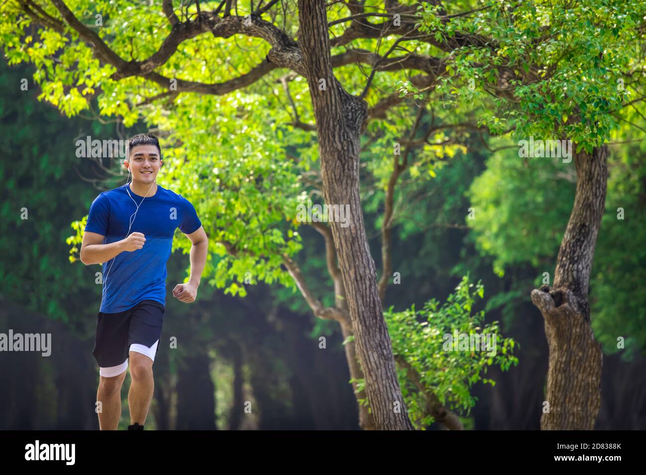 Jeune homme en forme physique et courant dans le parc Banque D'Images