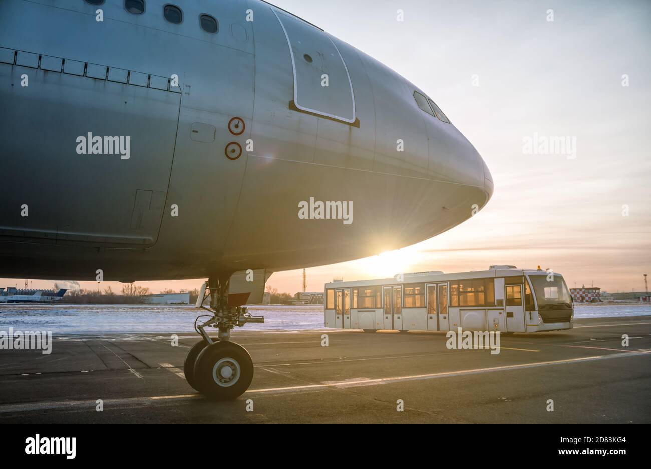 Avion passager et bus de l'aéroport à bord du tablier à l'intérieur les rayons du soleil couchant Banque D'Images