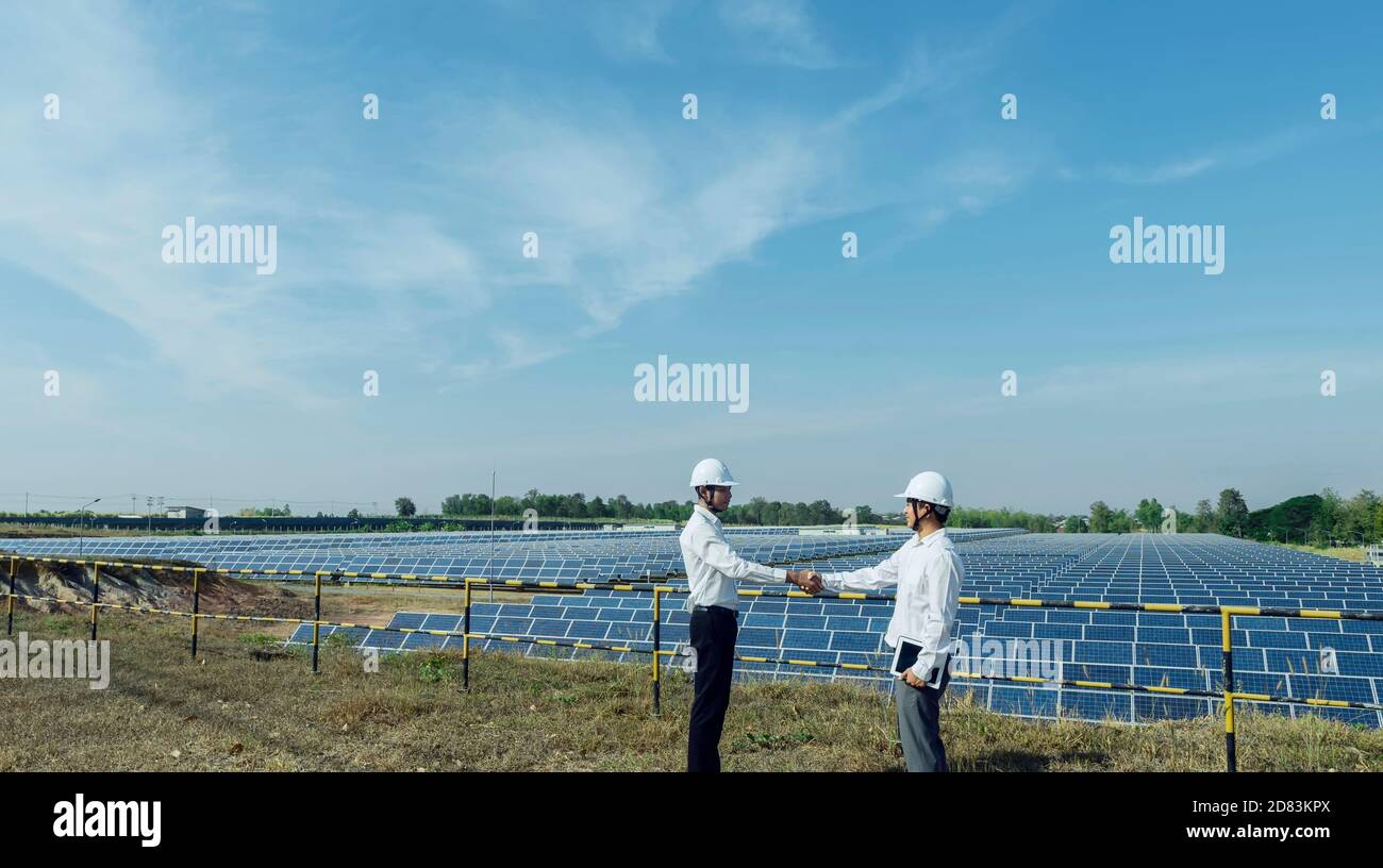 Homme d'affaires qui se secoue à la centrale d'énergie solaire, l'énergie alternative pour économiser l'énergie du monde, idée de module photovoltaïque pour produire de l'énergie propre Banque D'Images