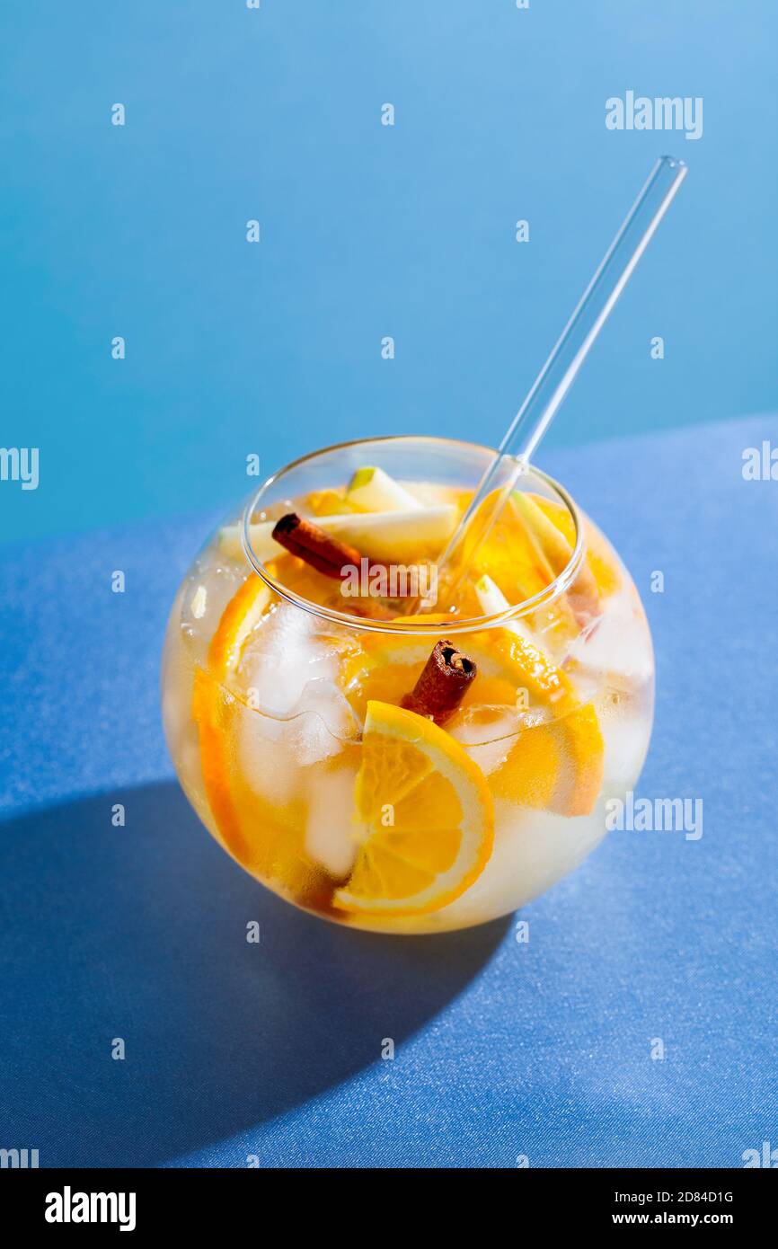 Cocktail de punch sangria à l'orange, à la pomme et à la cannelle sur fond bleu. Boisson aux fruits pour la fête Banque D'Images