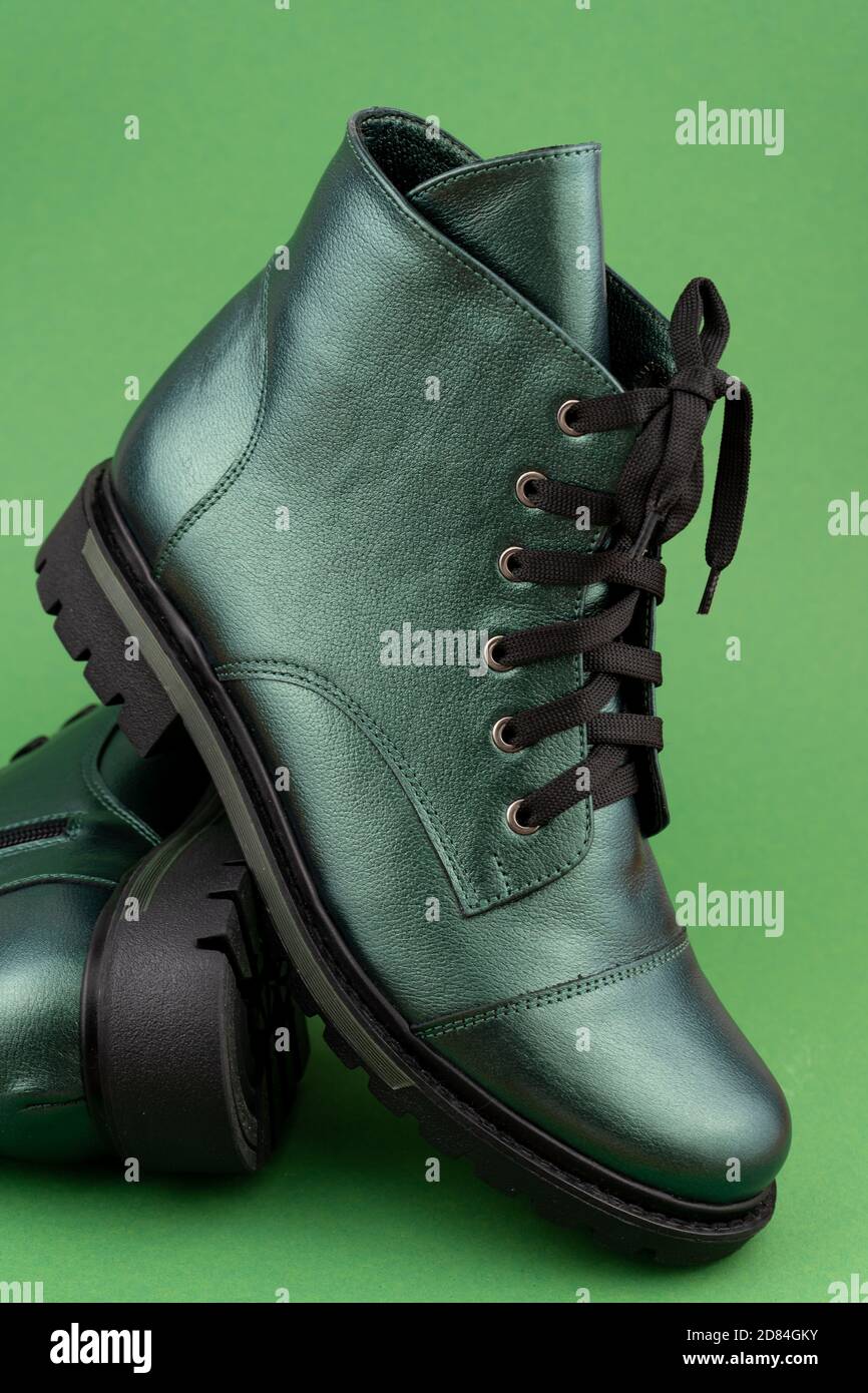 Chaussures en cuir vert. Bottes d'hiver et d'automne hors saison. Chaussure élégante isolée en arrière-plan. Gros plan. Lacets, semelle de tracteur, pour une durée de vie confortable. Décontracté Banque D'Images