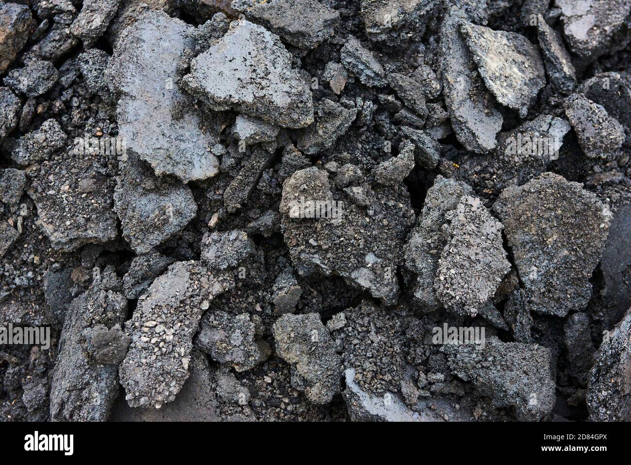 Morceaux d'asphalte cassés sur un chantier de construction. Recyclage et réutilisation des gravats de béton écrasés, de l'asphalte, des matériaux de construction, des blocs. Concassé Banque D'Images